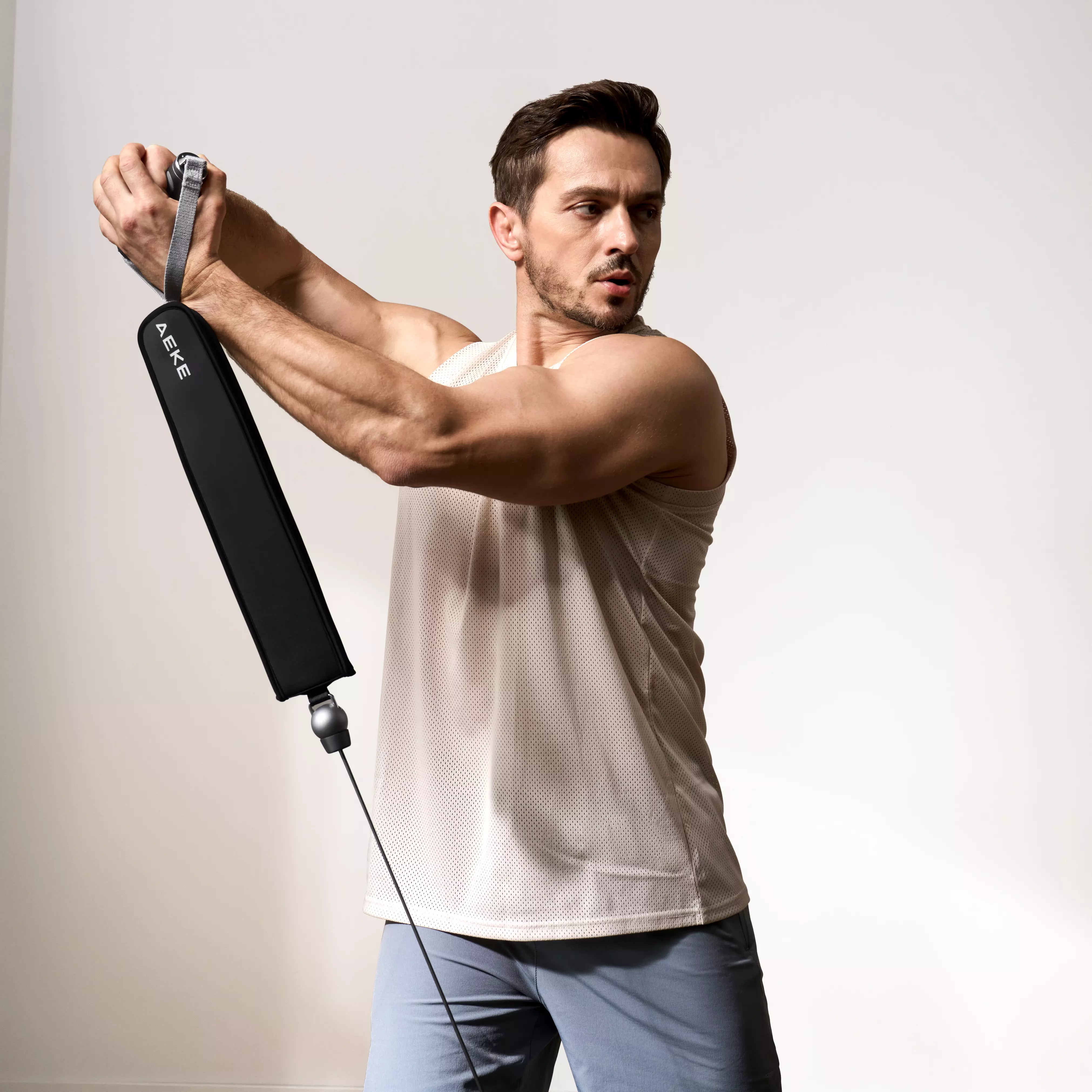 A man performing a standing torso rotation using a smart cable home gym.