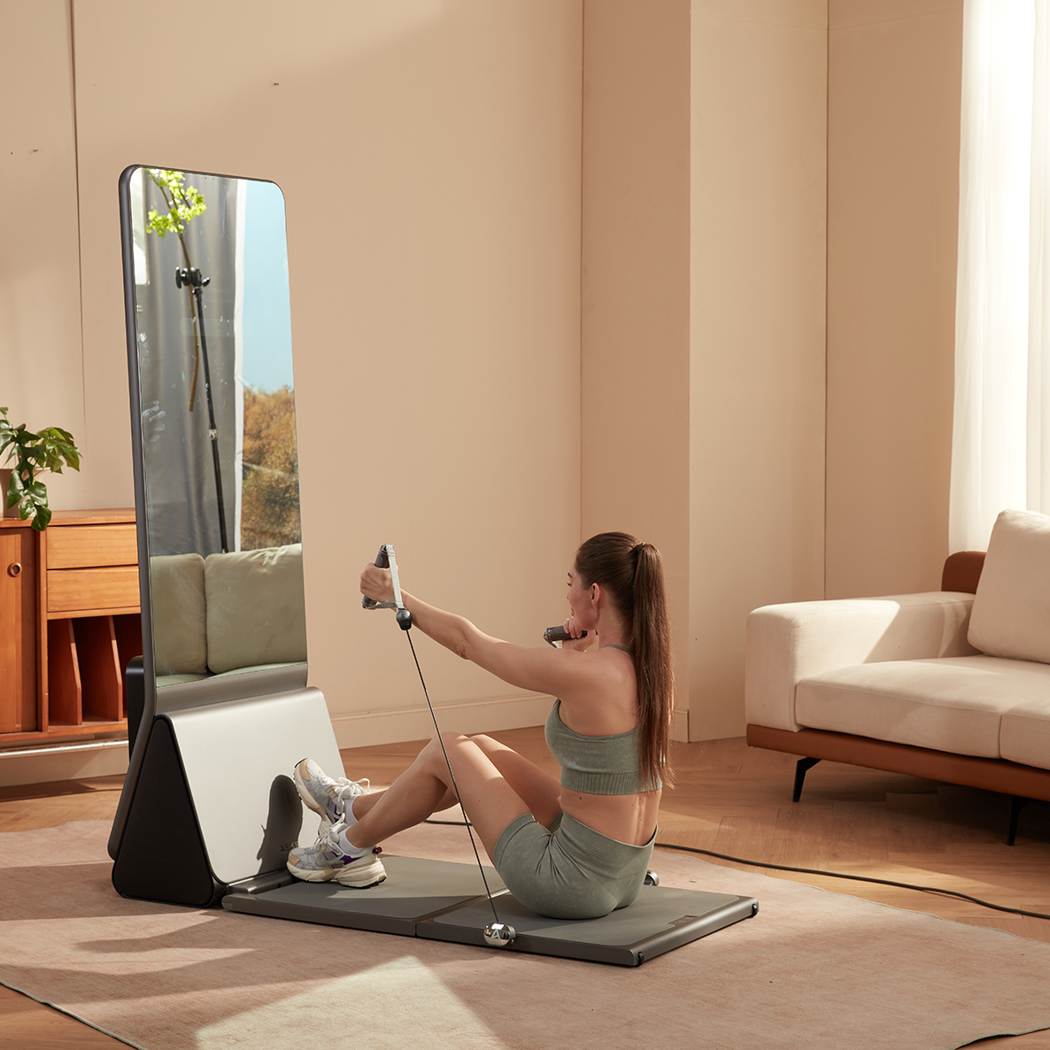  A woman performing seated cable rows using a smart home gym mirror.